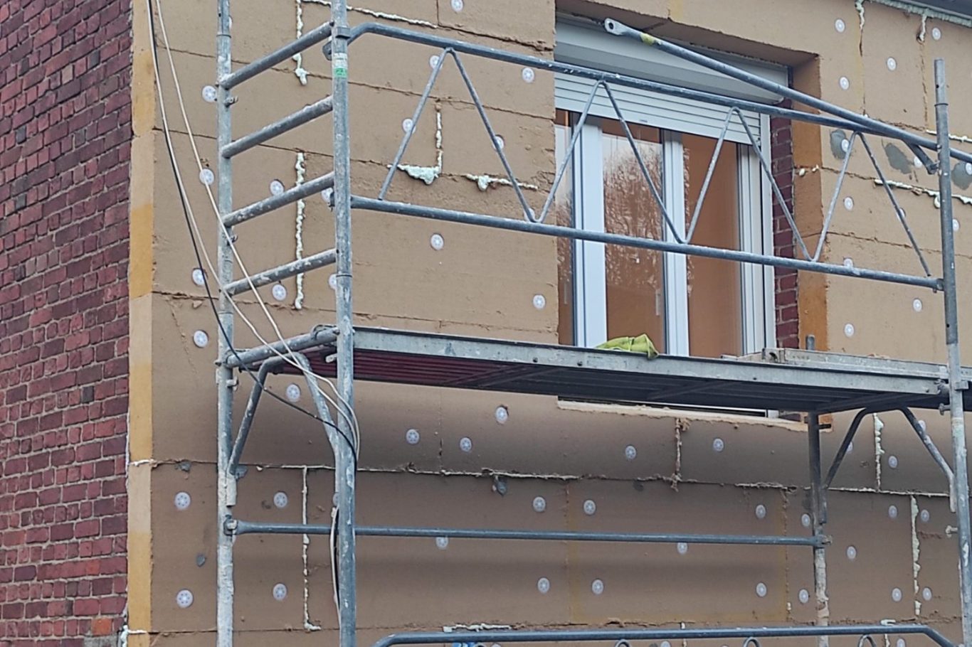 façadier qui pose un enduit projeté sur une façade ou un pignon de maison